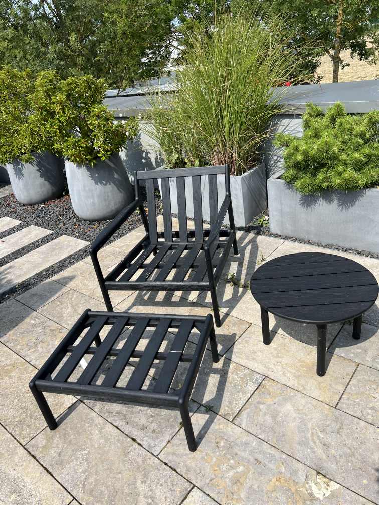 Schwarze Jack Outdoor Sitzgruppe von Ethnicraft mit Sessel, Hocker und kleinem Tisch für den Garten.