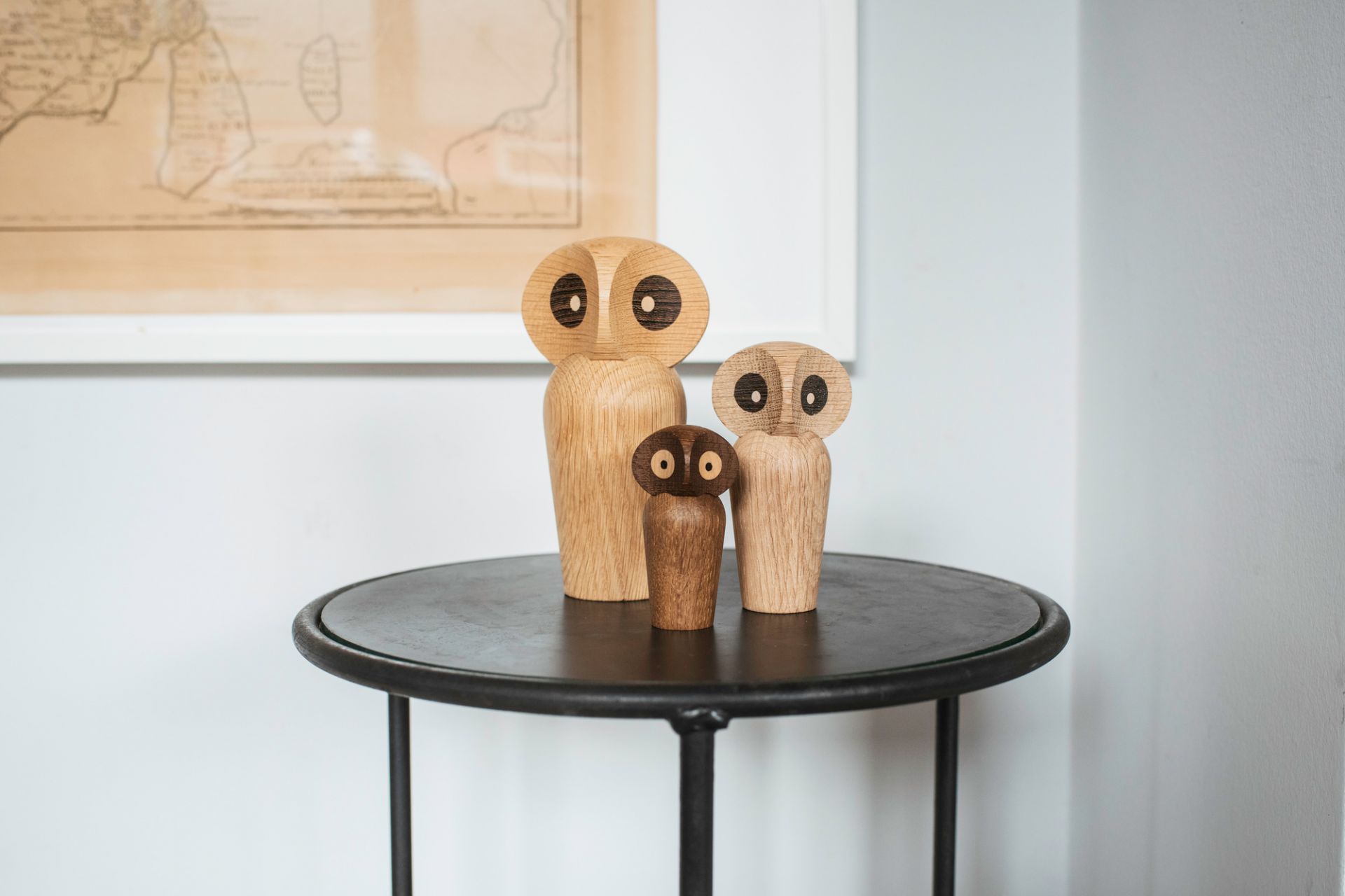 Drei Architectmade Owl Holzfiguren auf einem Tisch, dekorative Eulen aus Holz, skandinavisches Design.