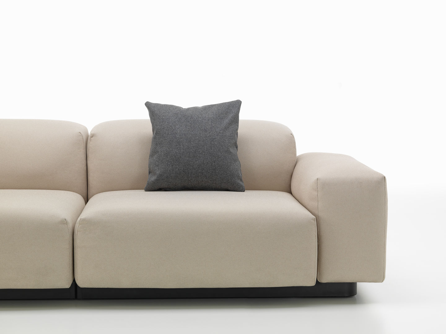 Vitra Kissen: Graues Sofakissen auf einem beigen Sofa, modernes Wohnzimmer-Accessoire für mehr Komfort.