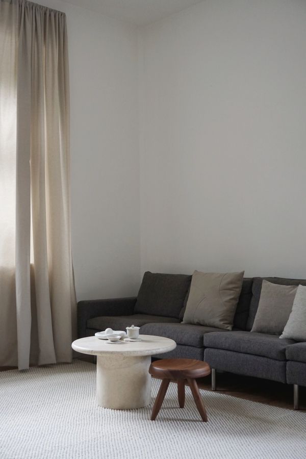 Heller Tact Rug Teppich von Woud (200x300 cm) im Wohnzimmer unter Couchtisch und Hocker.