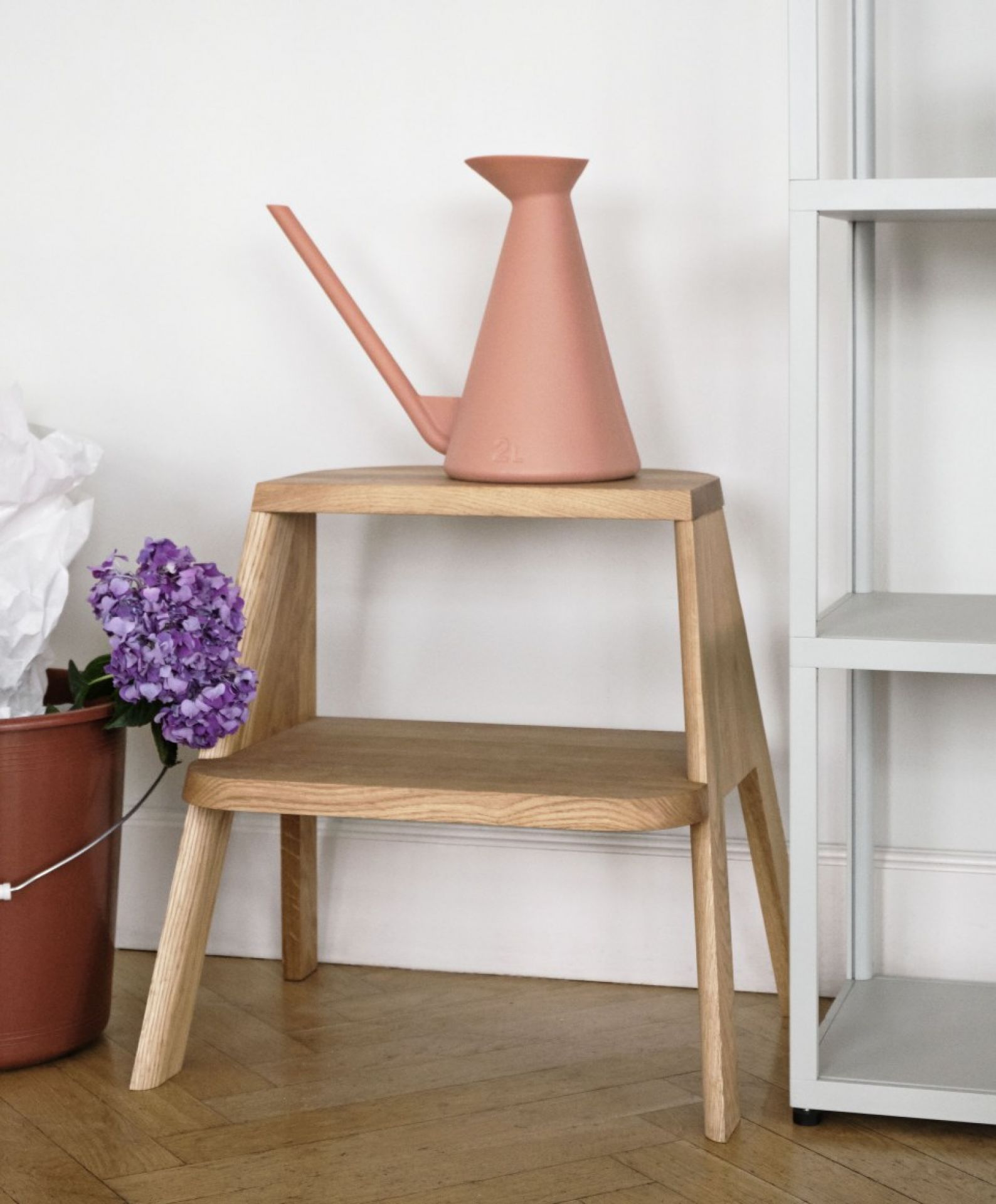 Butler Hocker von Hay aus Eichenholz mit rosa Gießkanne und lila Hortensie im Eimer.