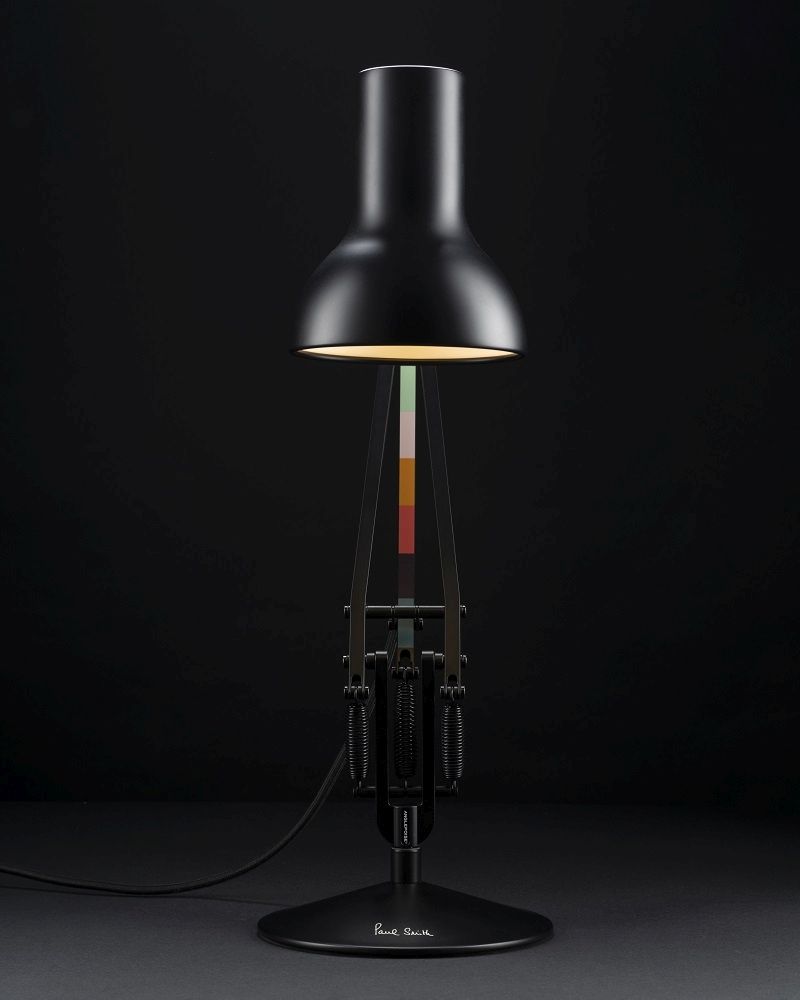 Schwarze Anglepoise Type 75 Mini Paul Smith Edition Tischleuchte mit farbigen Akzenten vor dunklem Hintergrund.