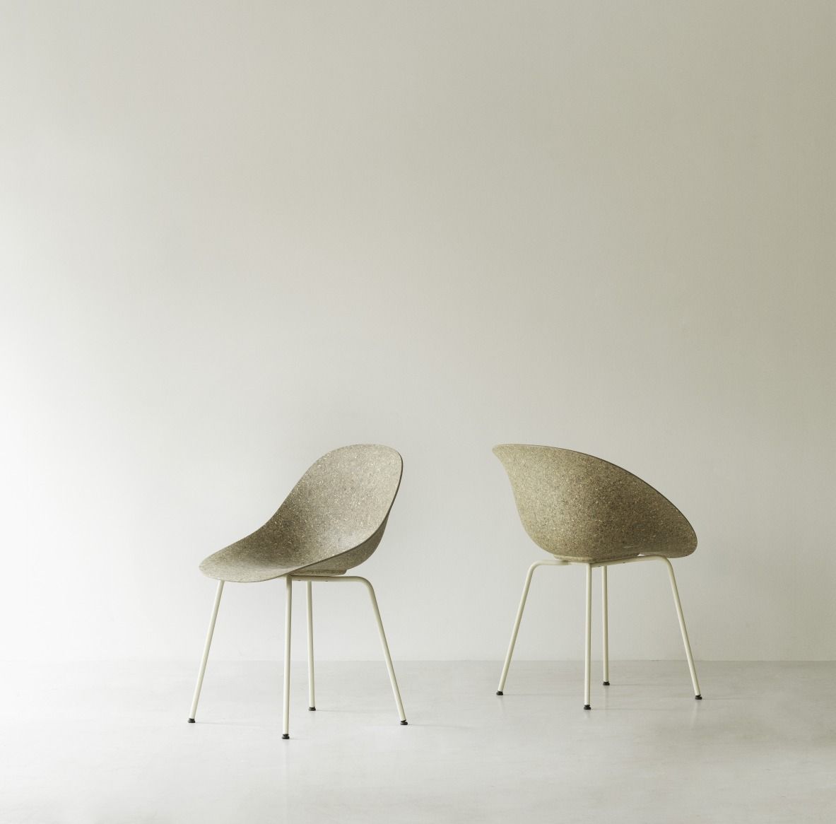 Zwei graue Mat Armchair Stühle von Normann Copenhagen mit Stahlgestell vor einer weißen Wand.