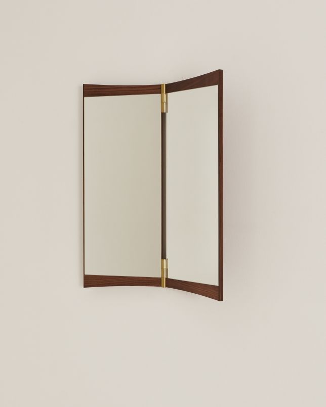 Gubi Vanity Wall Mirror 2 Wandspiegel mit Holzrahmen und Messingdetails an einer hellen Wand.