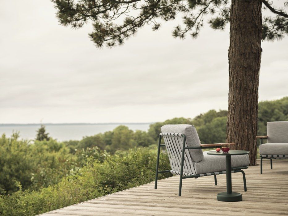 Muuto Settle Lounge Chair Outdoor Sessel mit Abdeckhaube auf Holzterrasse.