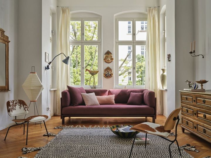 Wohnzimmer mit burgunderrotem Sofa und Vitra Anagram Panel 90 cm an der Wand.