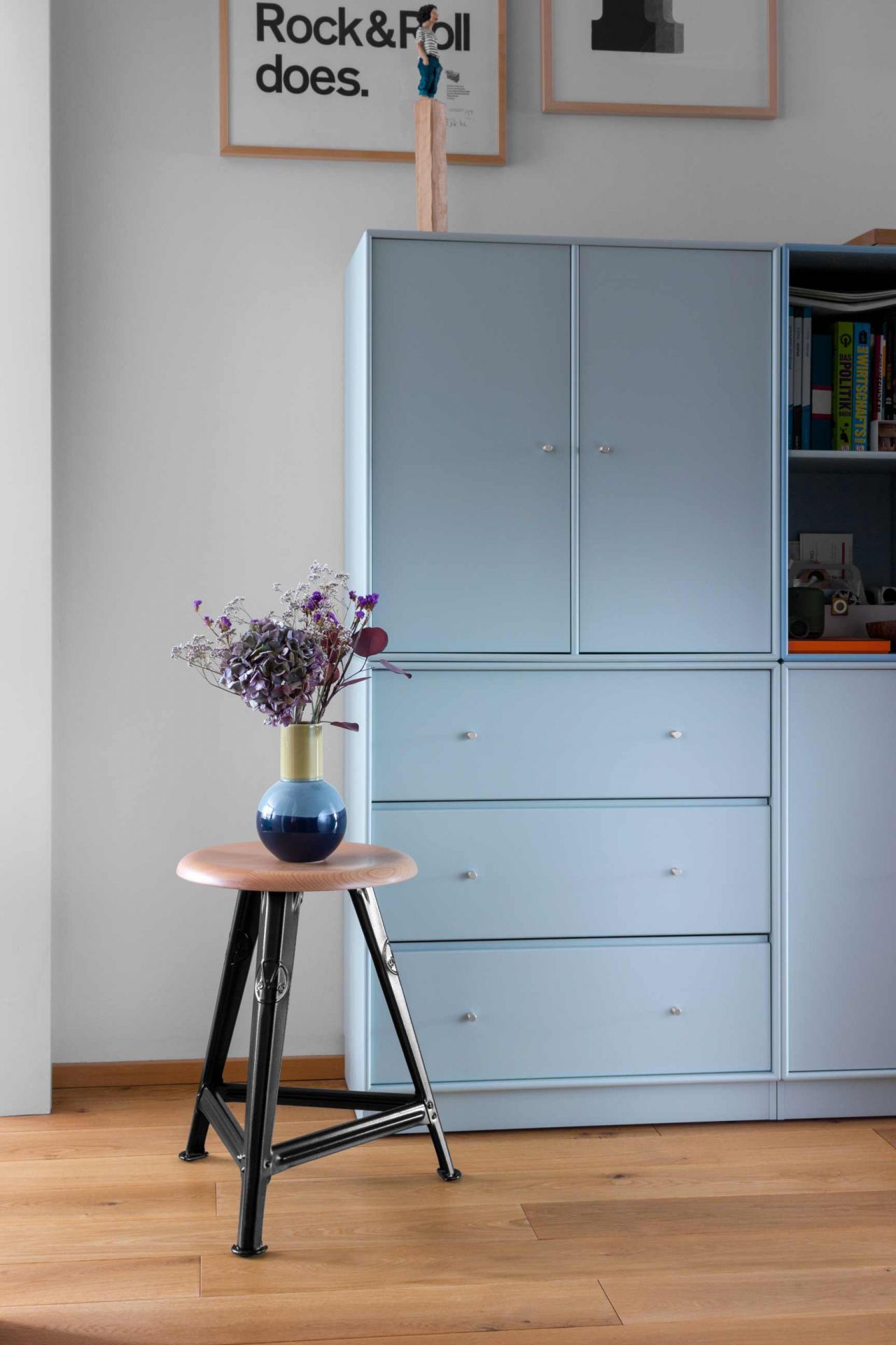 Schemel Model I 50 cm Hocker Rowac aus Holz und Metall mit Blumen in blauer Vase.