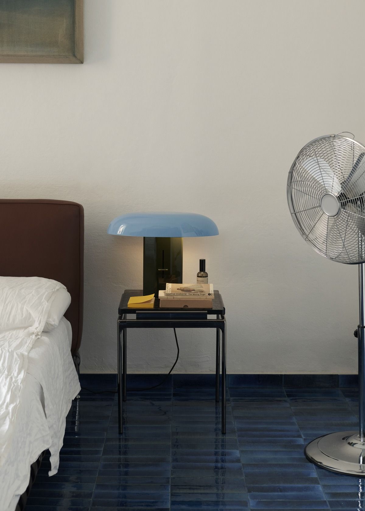 AndTradition Sett LN11 Beistelltisch im Schlafzimmer: Schwarzer Nachttisch mit Lampe, Büchern und Ventilator.