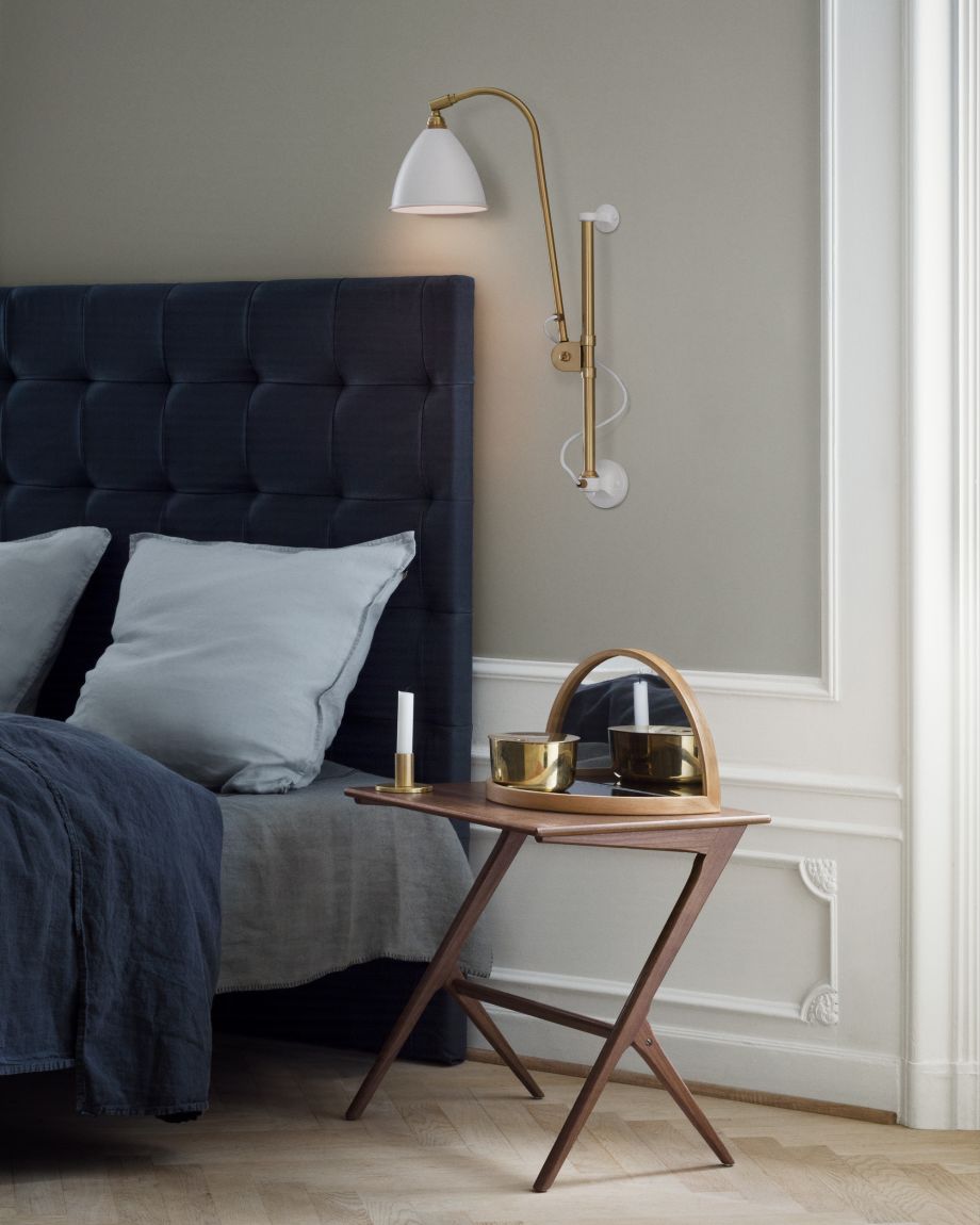 Bestlite BL5 Wandleuchte in Weiß und Messing über Nachttisch im Schlafzimmer. Designleuchte von Gubi.