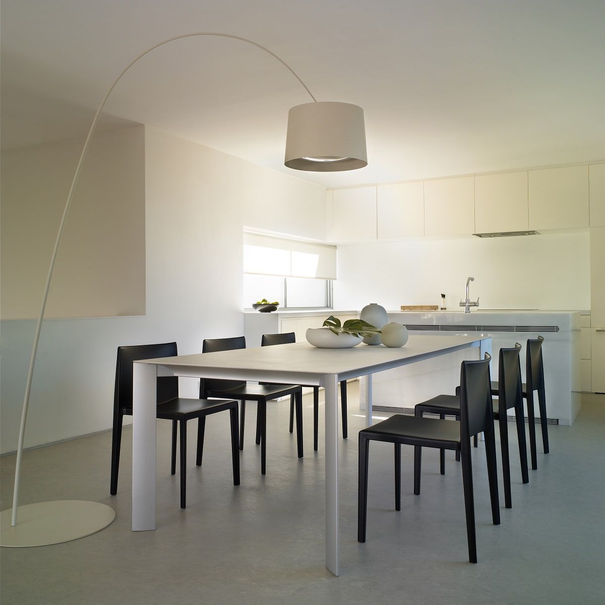 Esstisch mit sechs schwarzen Andreu World Sail SI1245 Stühlen in modernem, minimalistischem Esszimmer mit Bogenlampe.