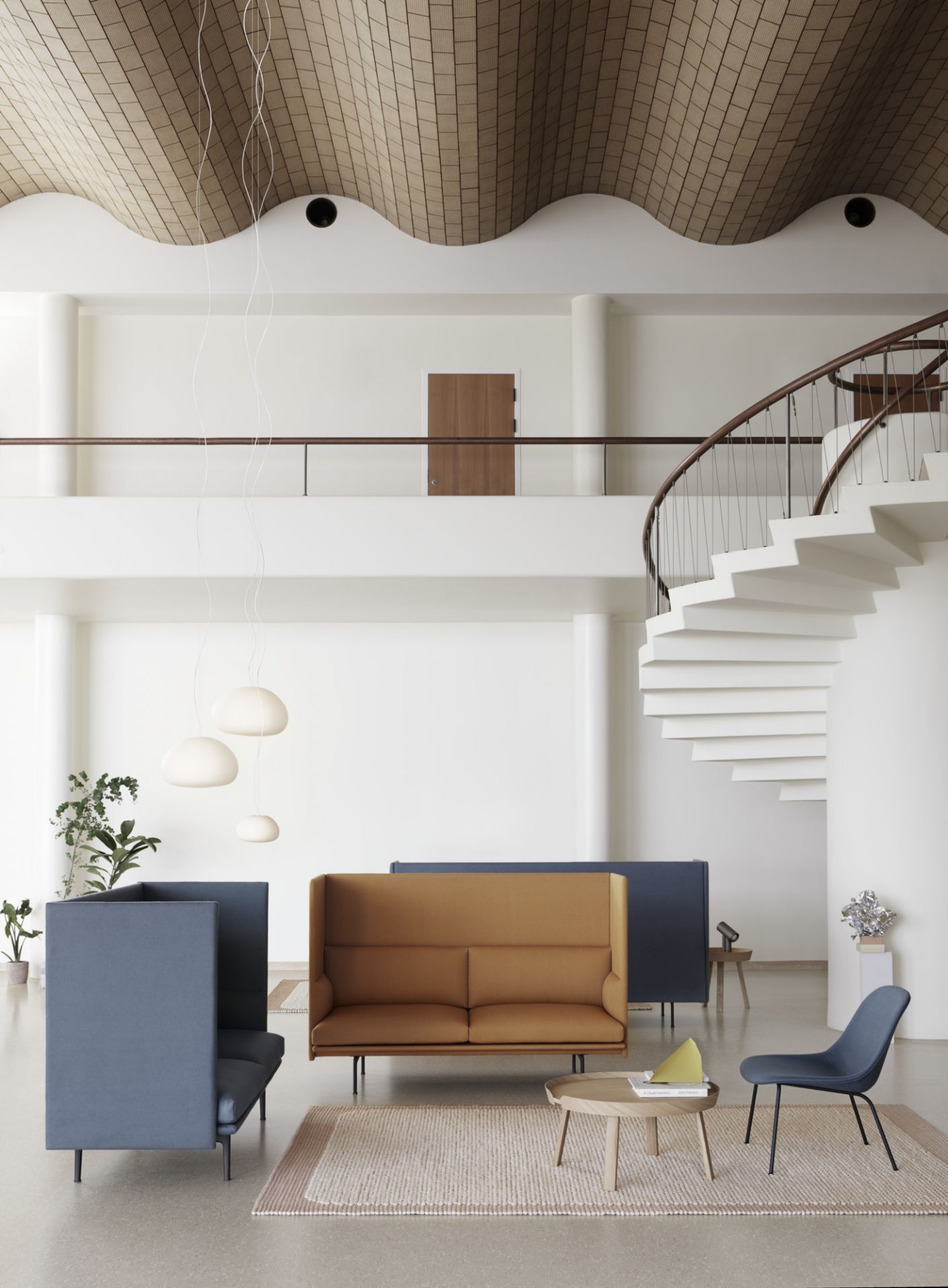 Helle, moderne Büroeinrichtung mit Muuto Beam Lamp Pendelleuchten, Sofas und Wendeltreppe.