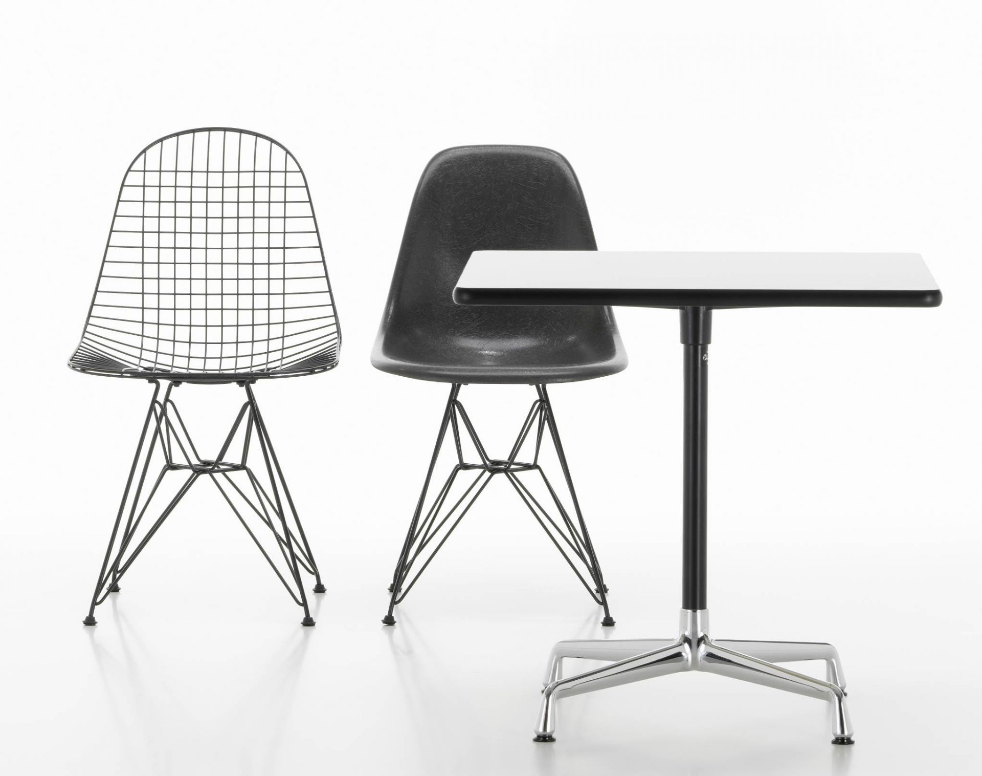 Vitra Eames Contract Table mit zwei Eames Stühlen in Schwarz und Draht-Optik.