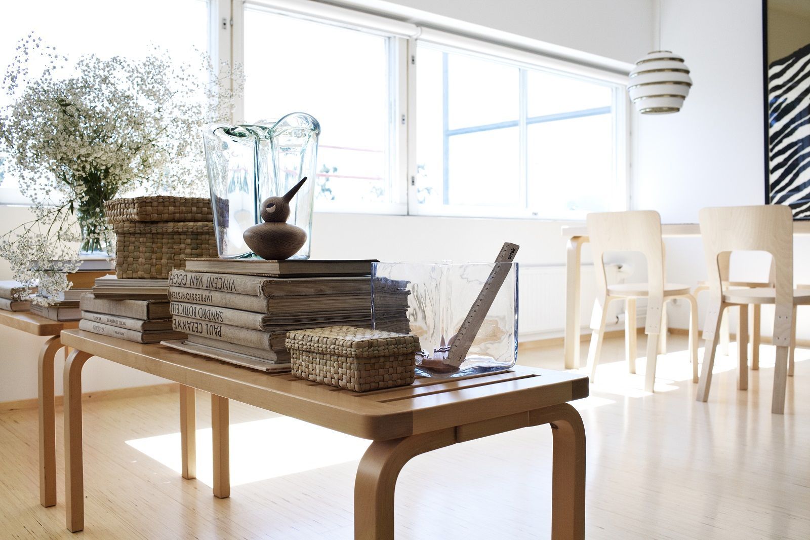 Artek Bench 153A aus Birkenholz im Interieur mit Dekorationen wie Bücher, Vasen und Körbe.