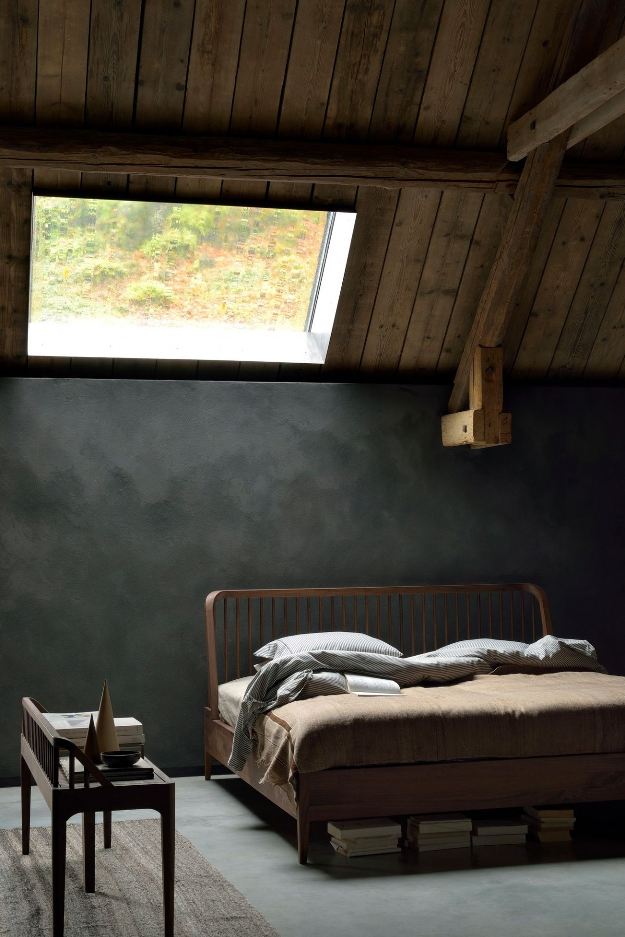 Spindle Bett von Ethnicraft aus Eiche im Schlafzimmer mit Dachfenster und Nachttisch.