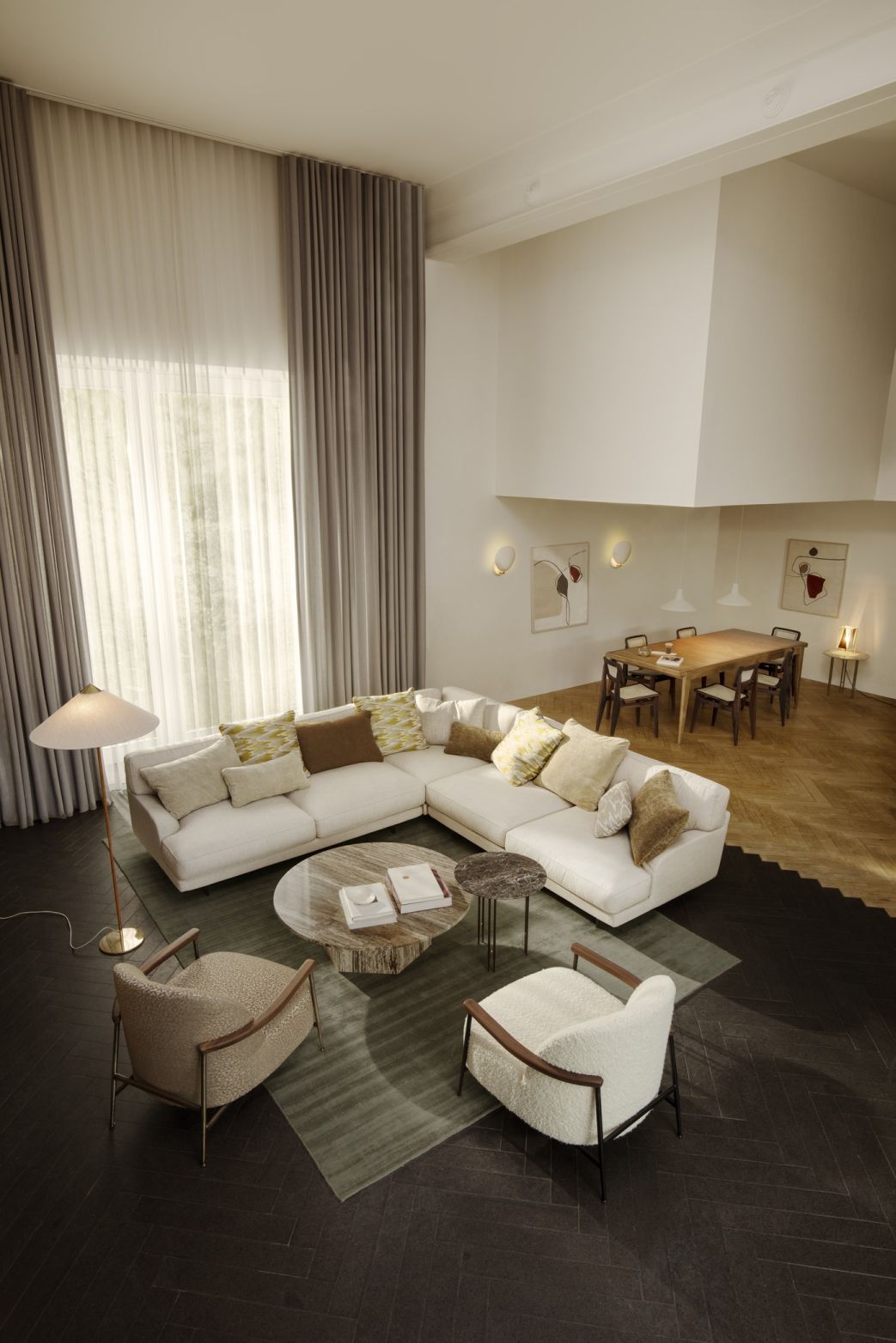 Helle Wohnzimmer-Szene mit Gubi S-Table Esstisch ausziehbar und großem Ecksofa unter hohen Decken.
