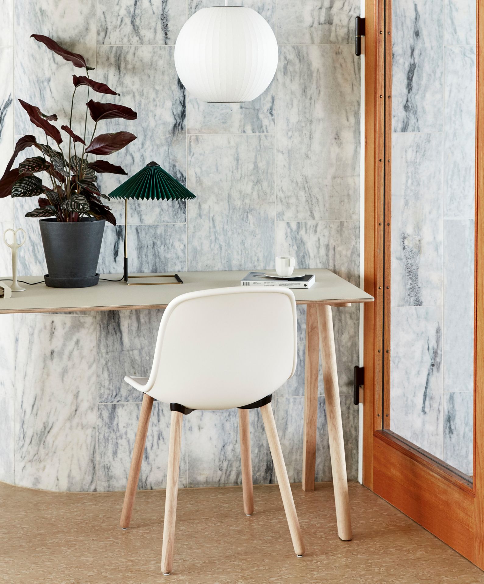 Copenhague Schreibtisch CPH 90 von Hay mit weißem Stuhl, Lampe und Pflanze vor Marmorwand.