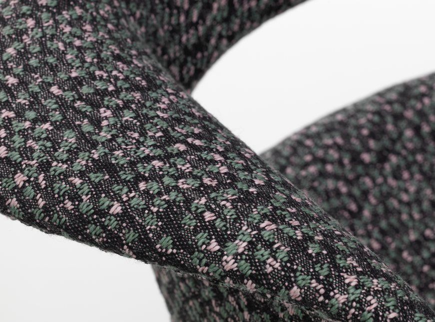 Detailaufnahme des Organic Conference Stuhls von Vitra mit Kvadrat Ria 03 Stoffmuster in Grün und Rosa.
