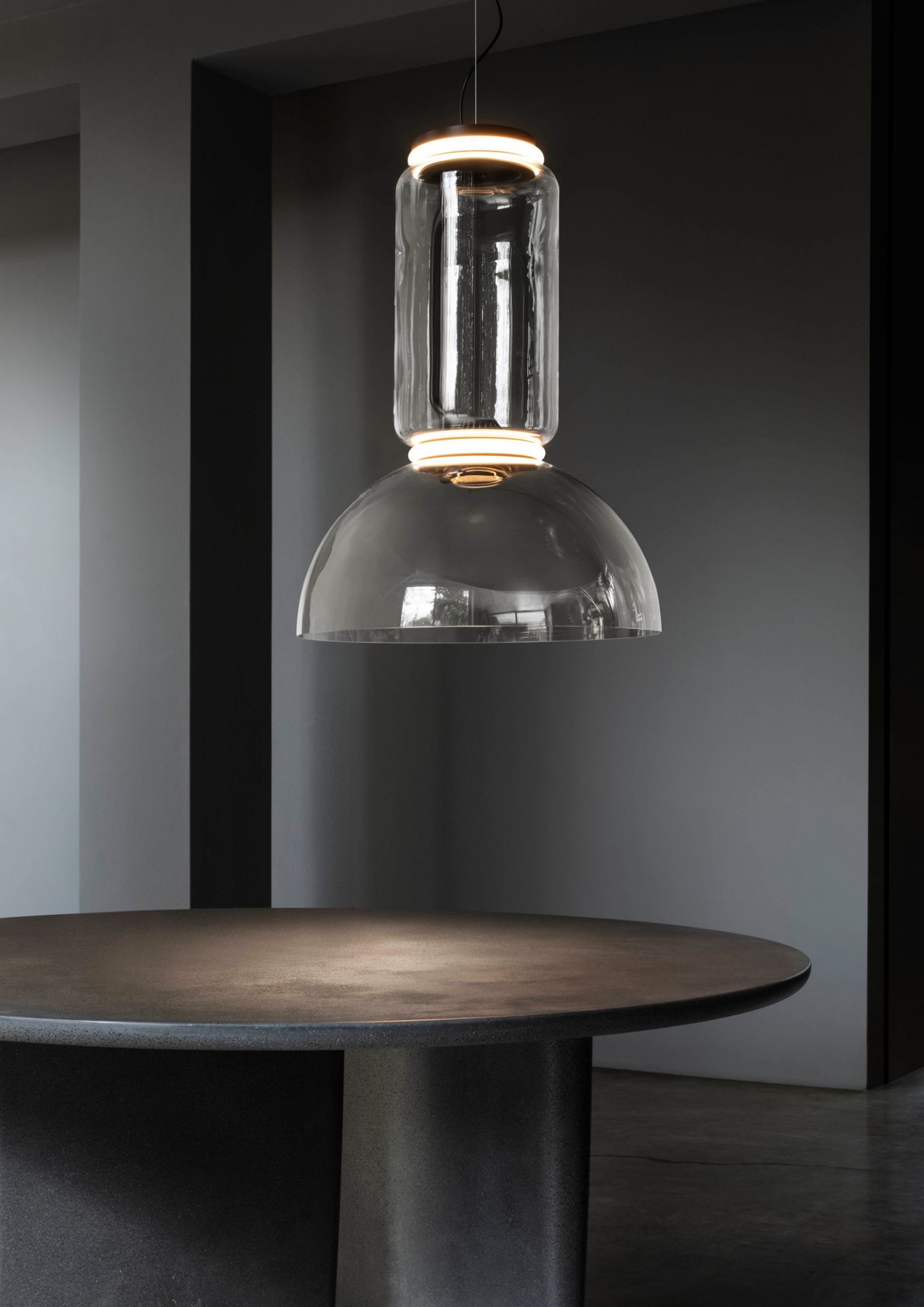 Noctambule Pendelleuchte von Flos: Moderne Hängelampe aus Glas mit LED-Beleuchtung über einem Tisch.