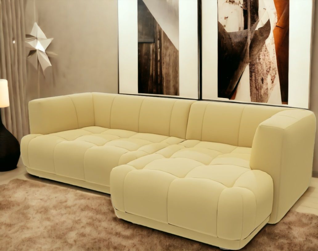 Beiges Quilton Combination Sofa 19 von Hay mit Ottomane und gesteppter Sitzfläche vor Kunstwerken.