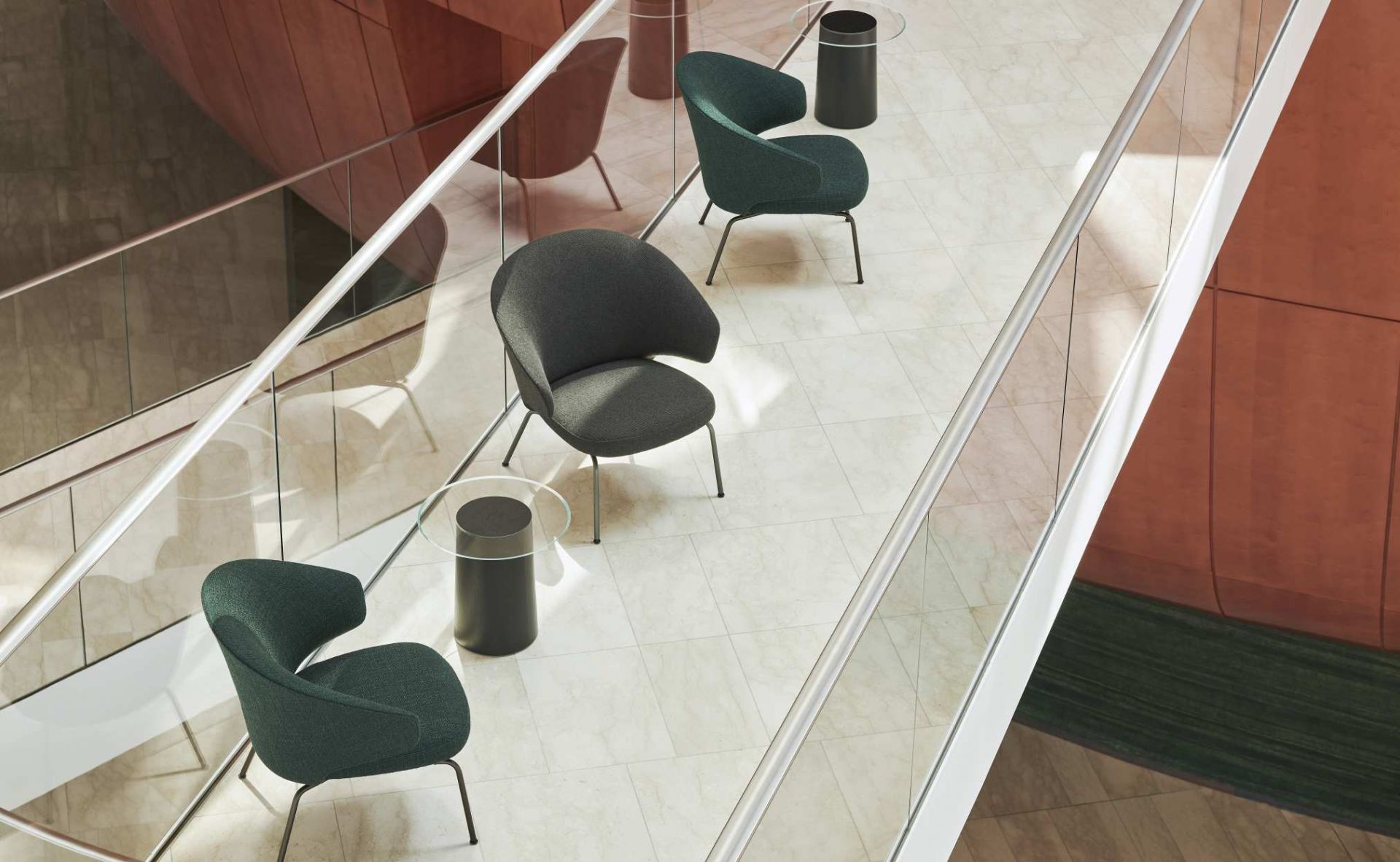Fritz Hansen Let Sessel in Grau und Grün auf modernem Marmorboden mit Glastisch.