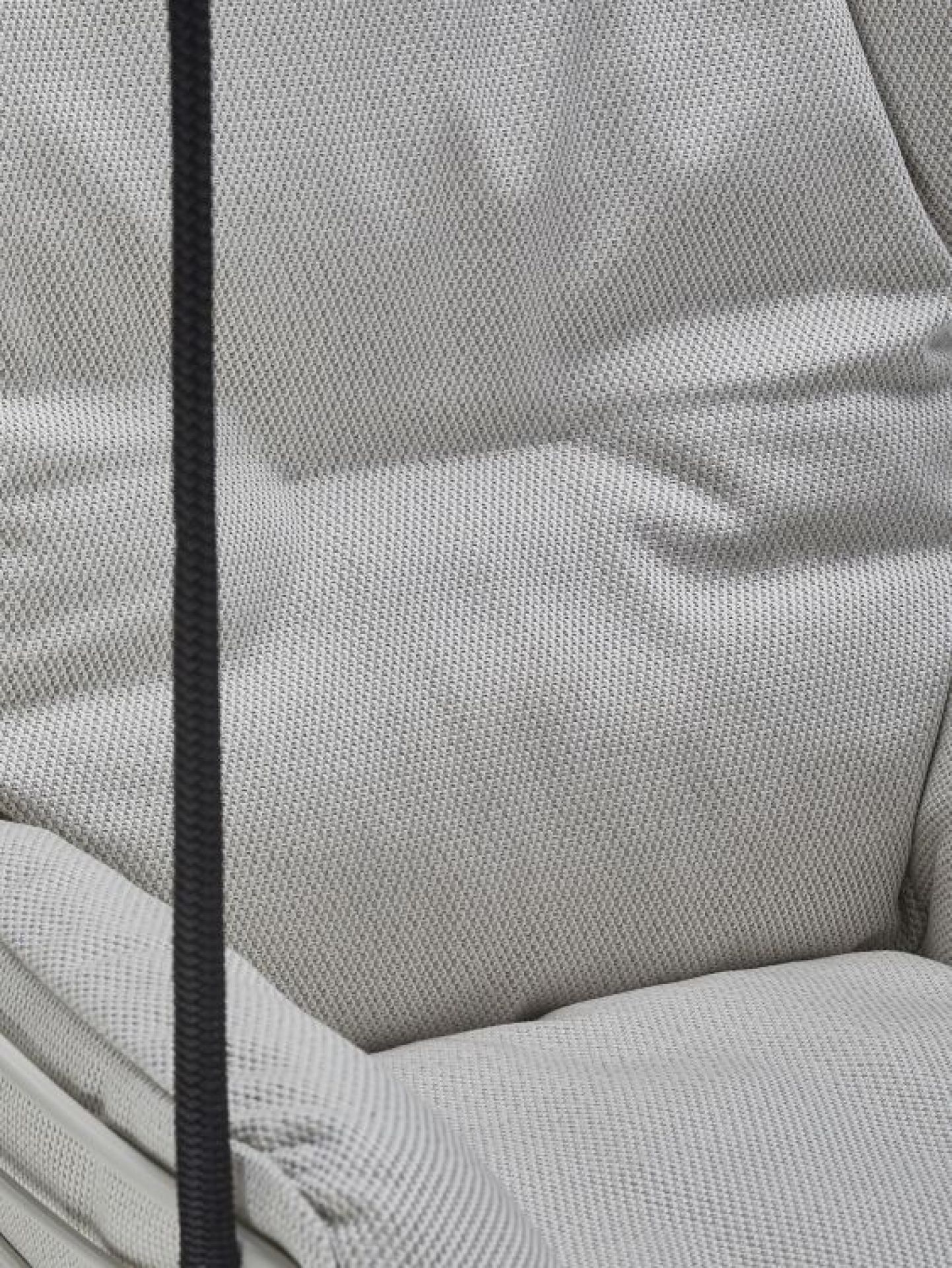 Detailaufnahme des hellgrauen Leyasol Lounge Chair Outdoor Stuhls von Freifrau Manufaktur, der Komfort und Stil für den Außenbereich vereint.