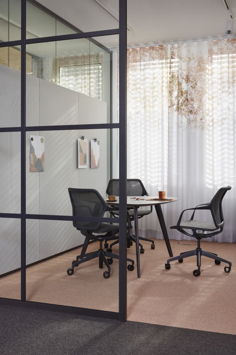Ray Work Drehstühle von Brunner um einen runden Tisch in einem modernen Büroraum.