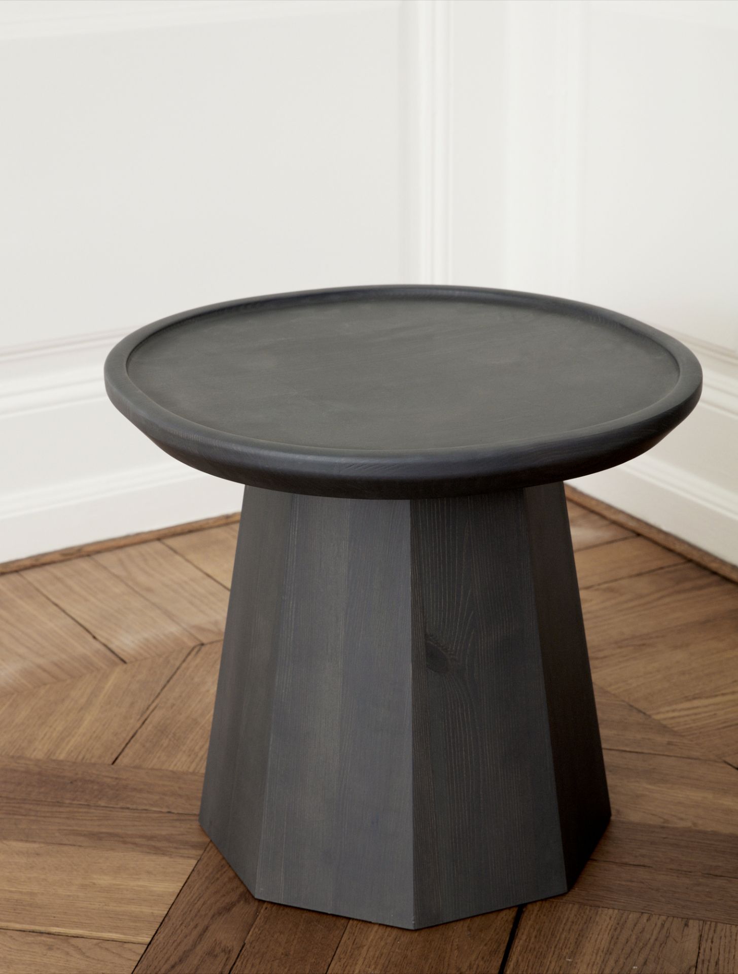Nahaufnahme des Pine Table Small Beistelltischs von Normann Copenhagen in dunklem Holz auf Parkettboden.