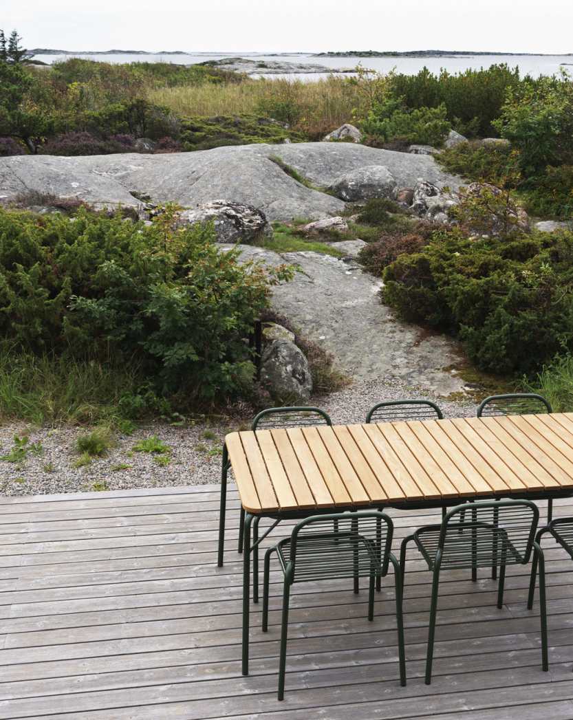 Normann Copenhagen Vig Tisch 90 x 200 cm mit Stühlen auf Holzterrasse im Außenbereich.