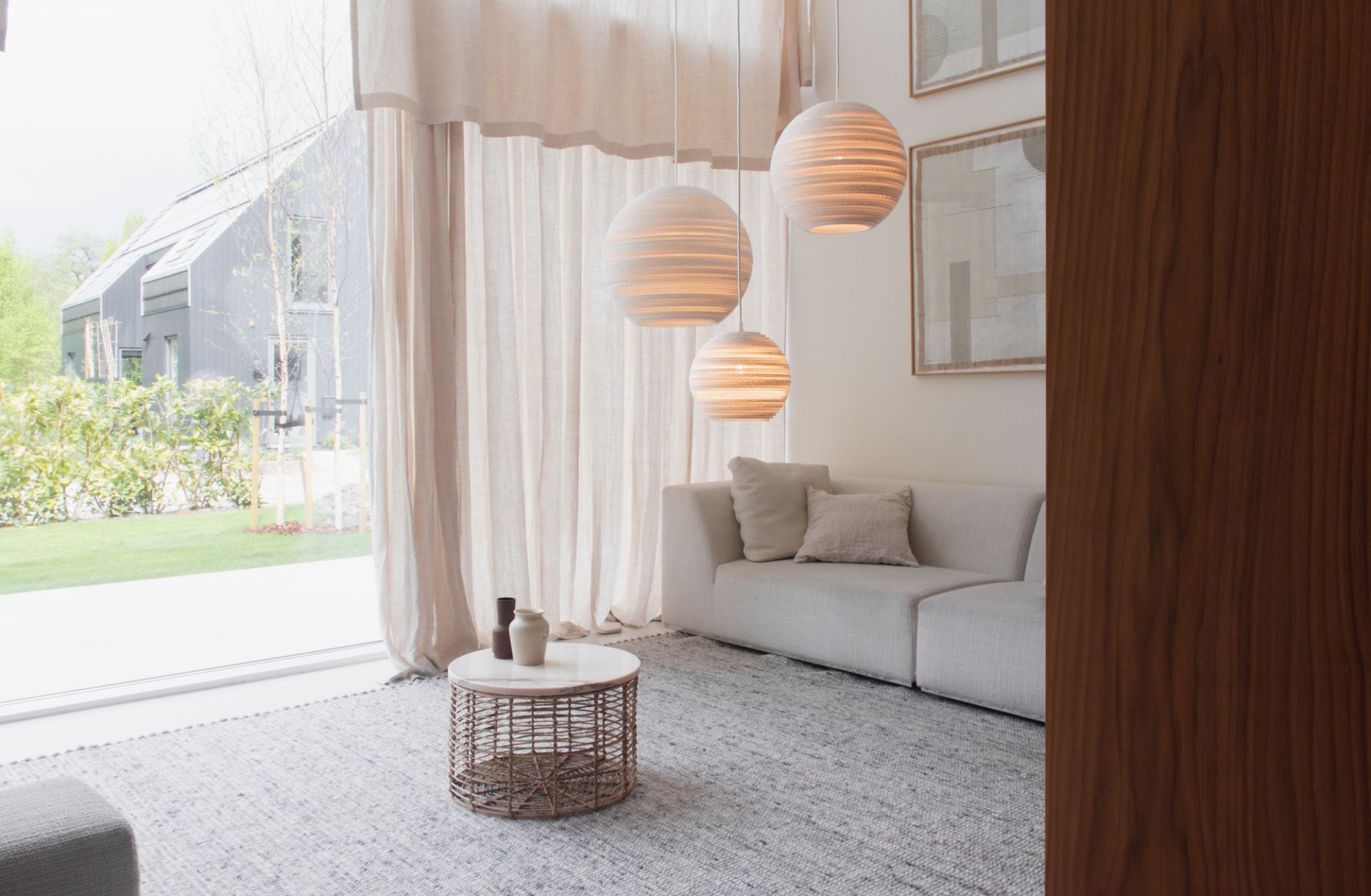 Scraplights Moon Hängeleuchten von Graypants in Weiß über Sofa im Wohnzimmer mit Tageslicht.