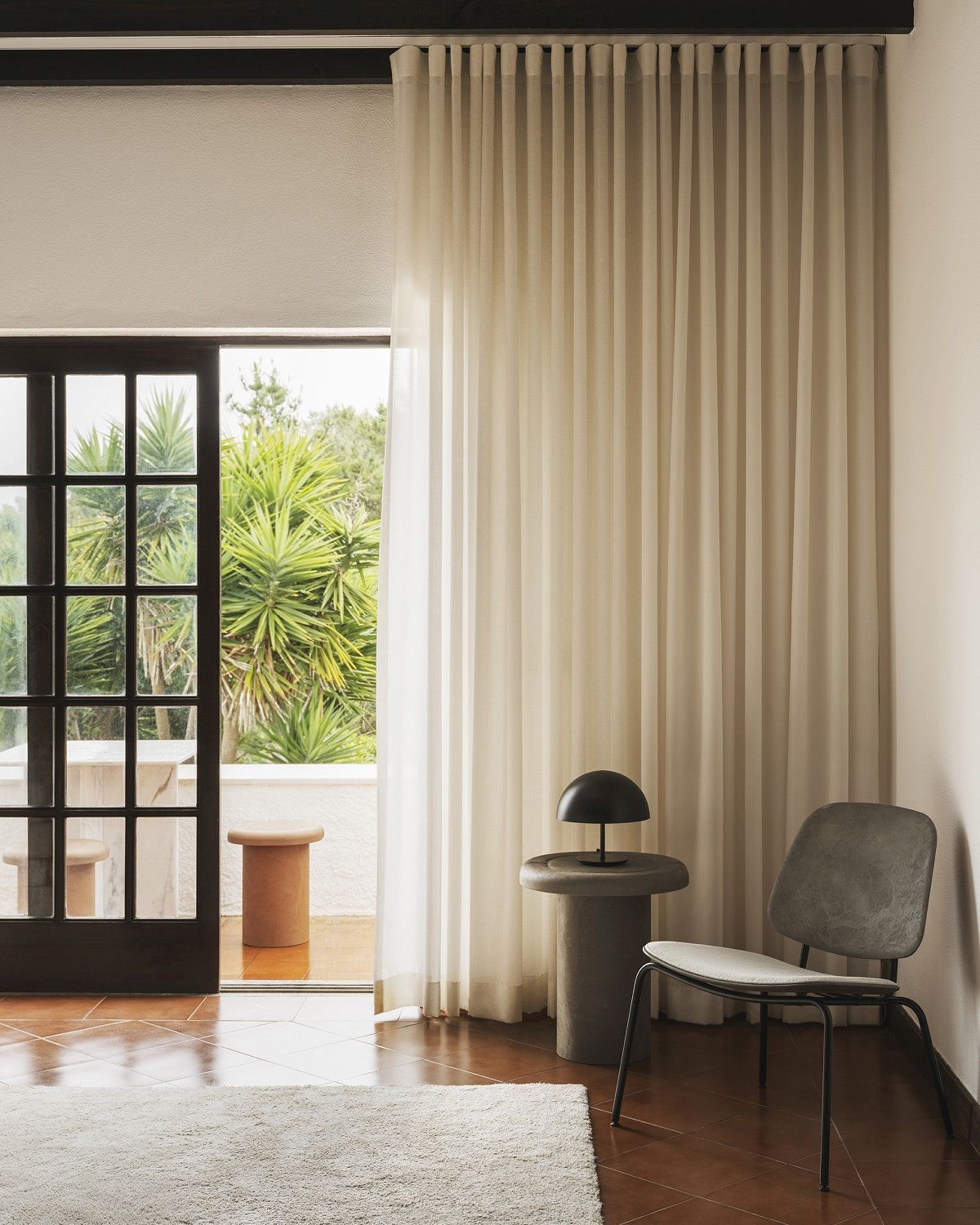 Mater Alder Beistelltisch im Innenraum mit Lampe und Stuhl, minimalistisches Design für Wohnzimmer und Terrasse.