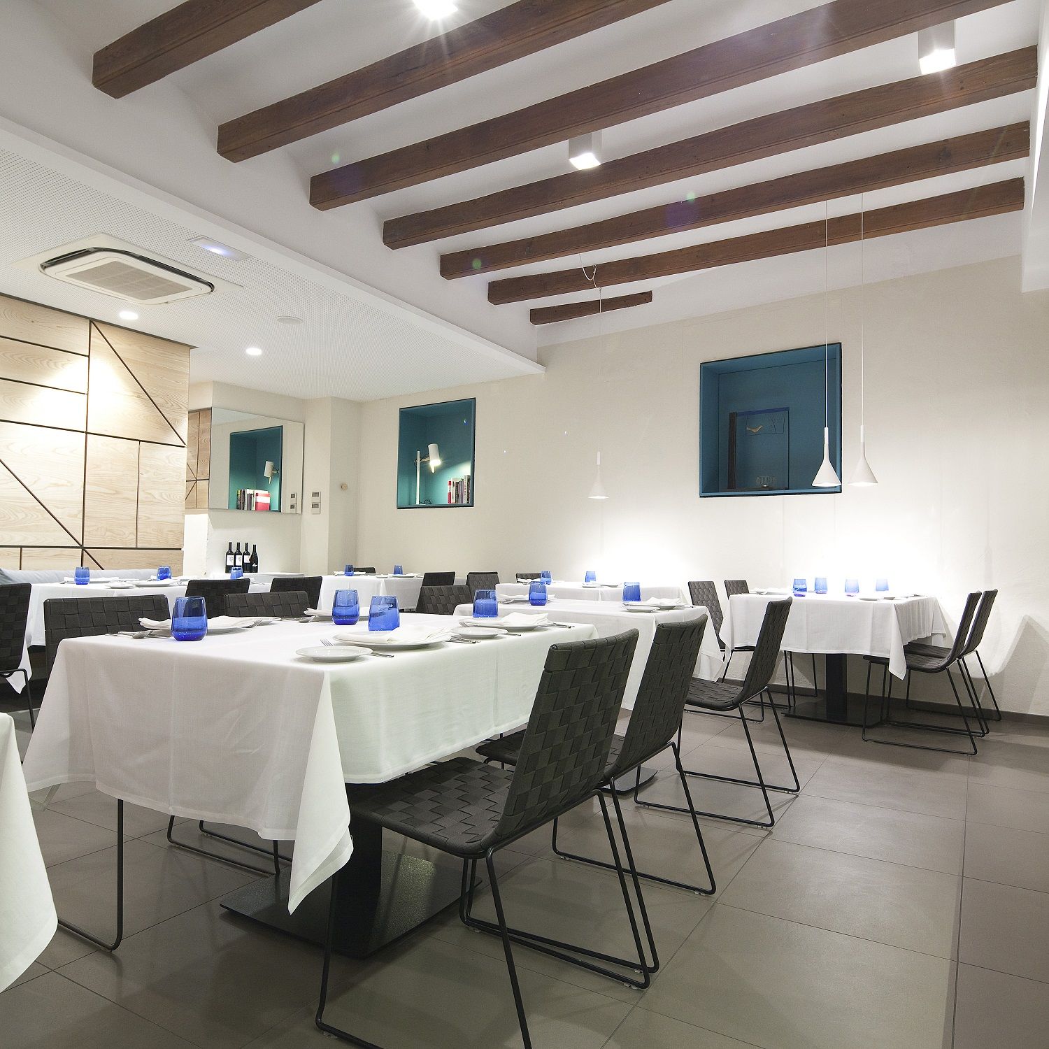 Innenaufnahme eines Restaurants mit Tischen und Andreu World Trenza SI0700 stapelbaren Outdoor Stühlen.
