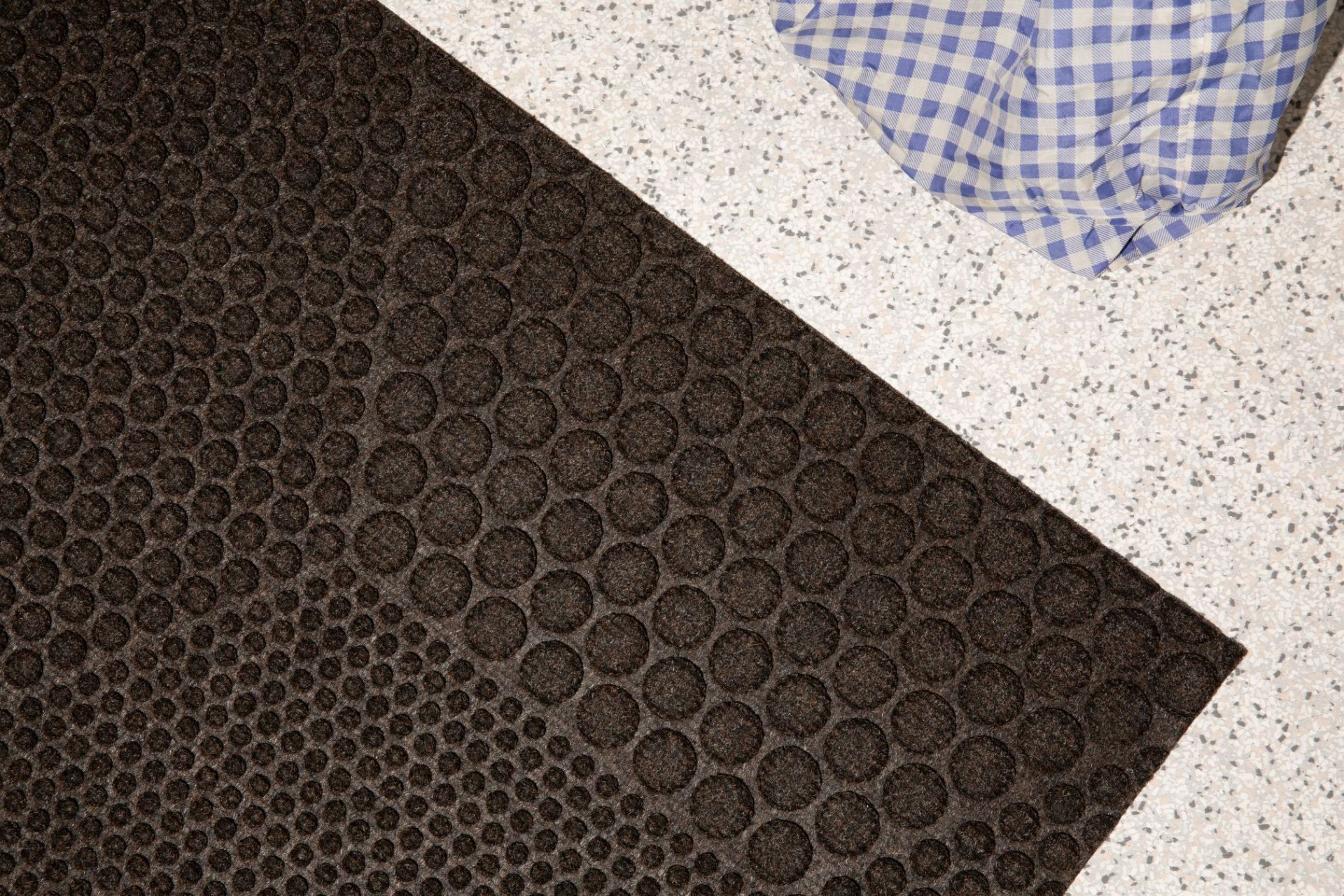 Nahaufnahme der braunen Hex Fußmatte Soil von Heymat mit kreisförmigem Muster.