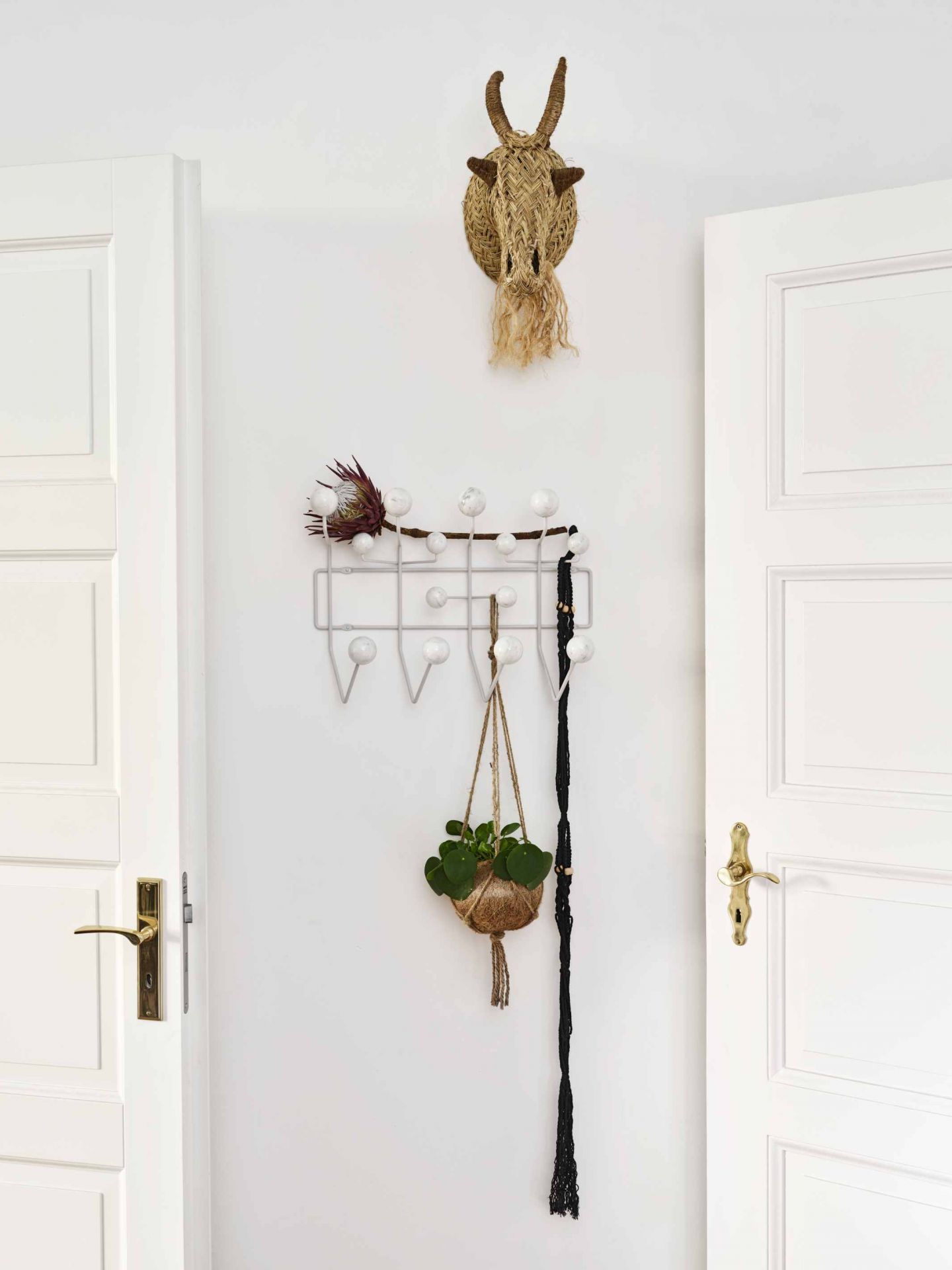 Eames Hang it all Garderobe Marmor Vitra LIMITED EDITION mit Dekoration an weißer Wand.