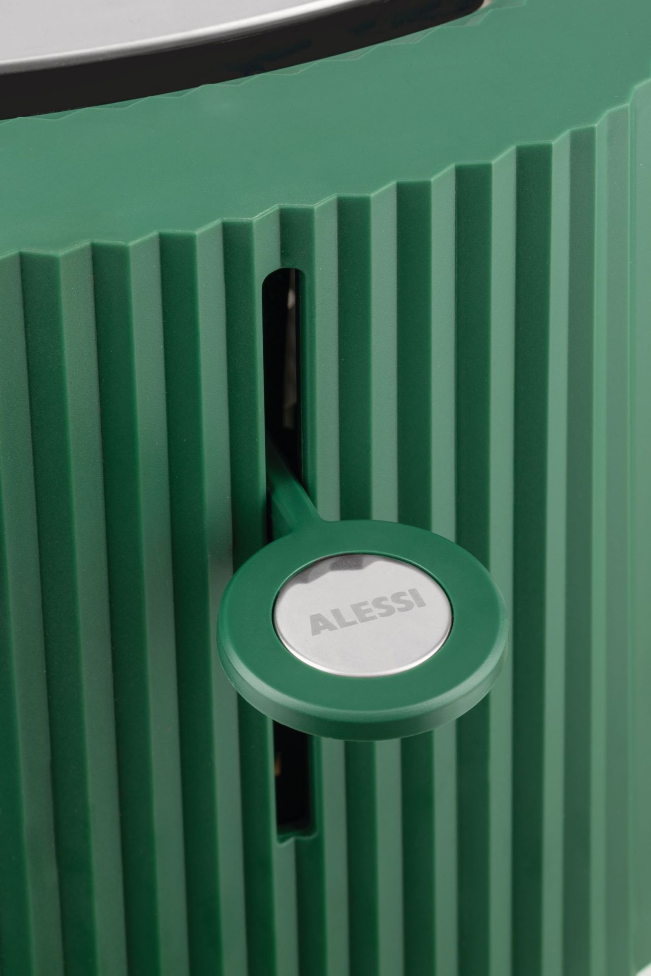Grüner Alessi Plissé Toaster: Detailaufnahme des Toasters mit plissiertem Design und Alessi-Logo. Küchengerät für stilvolles Toasten.