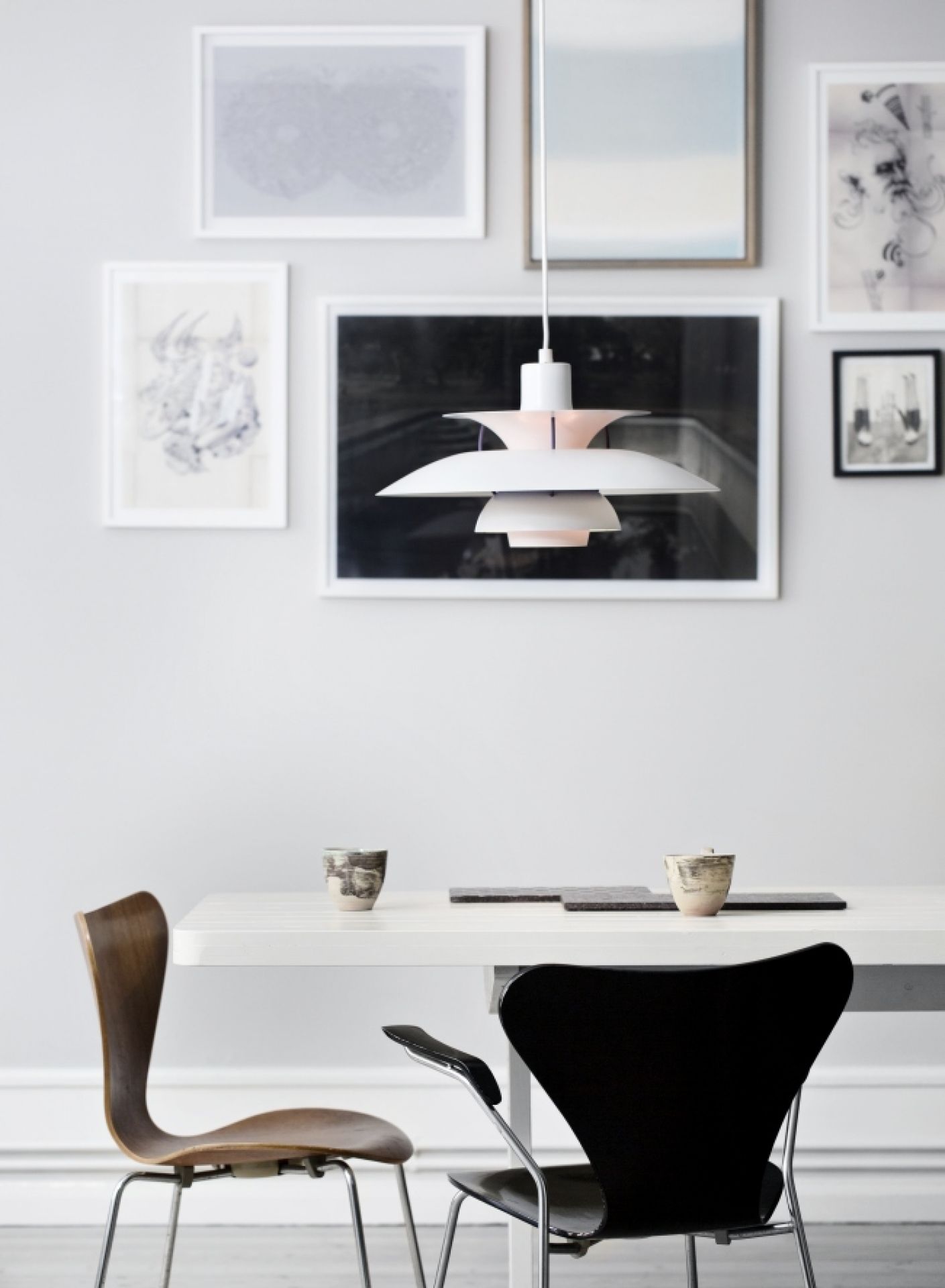 Moderne weiße PH 5 Pendelleuchte von Louis Poulsen über Esstisch mit Stühlen. Design Lampe.
