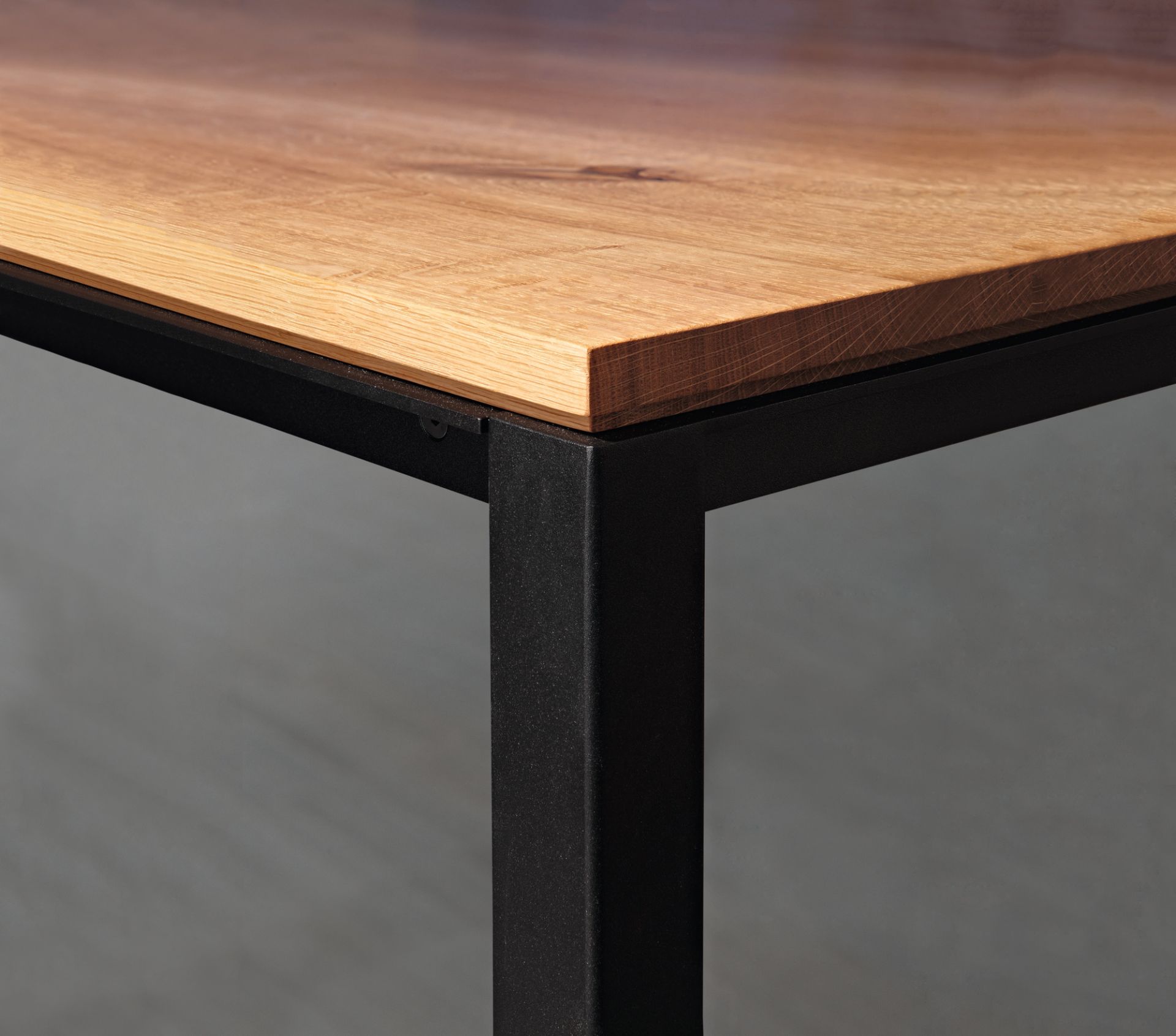 Detailaufnahme vom Janua S 600 Tisch: Tischplatte aus Eiche mit schwarzem Metallgestell.
