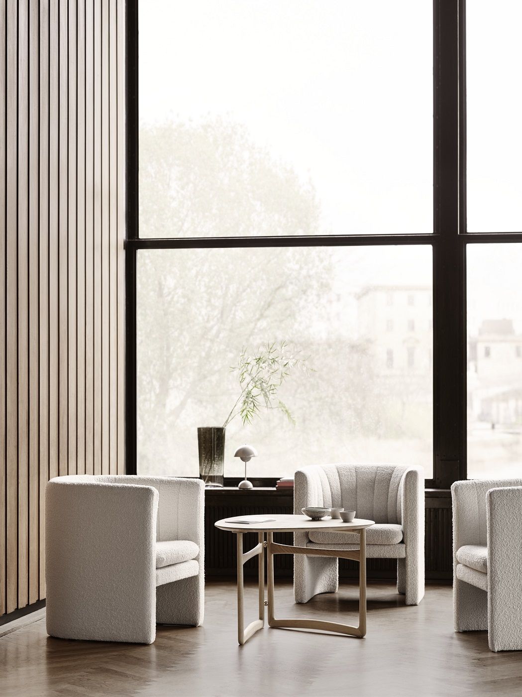 AndTradition Drop Leaf HM5 Lounge Table Beistelltisch aus Holz mit Sesseln in hellem Raum.