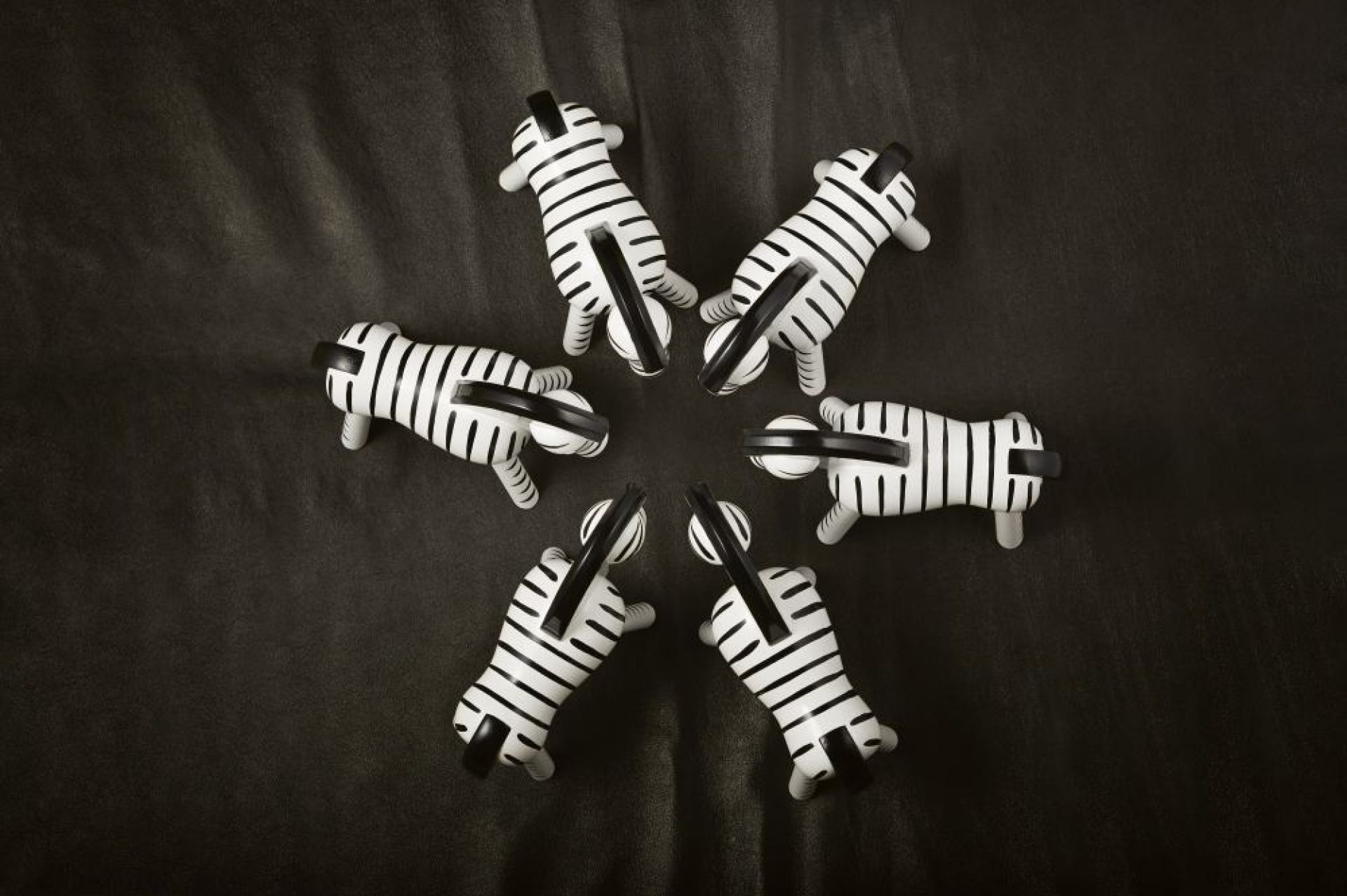 Fünf Kay Bojesen Zebra Holzfiguren, handgefertigt und Einzelstücke, auf dunklem Hintergrund angeordnet.