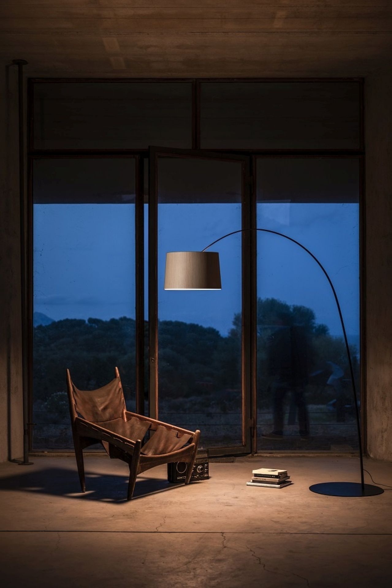 Twiggy Wood LED Stehleuchte von Foscarini neben Sessel und Büchern, modernes Wohnambiente.