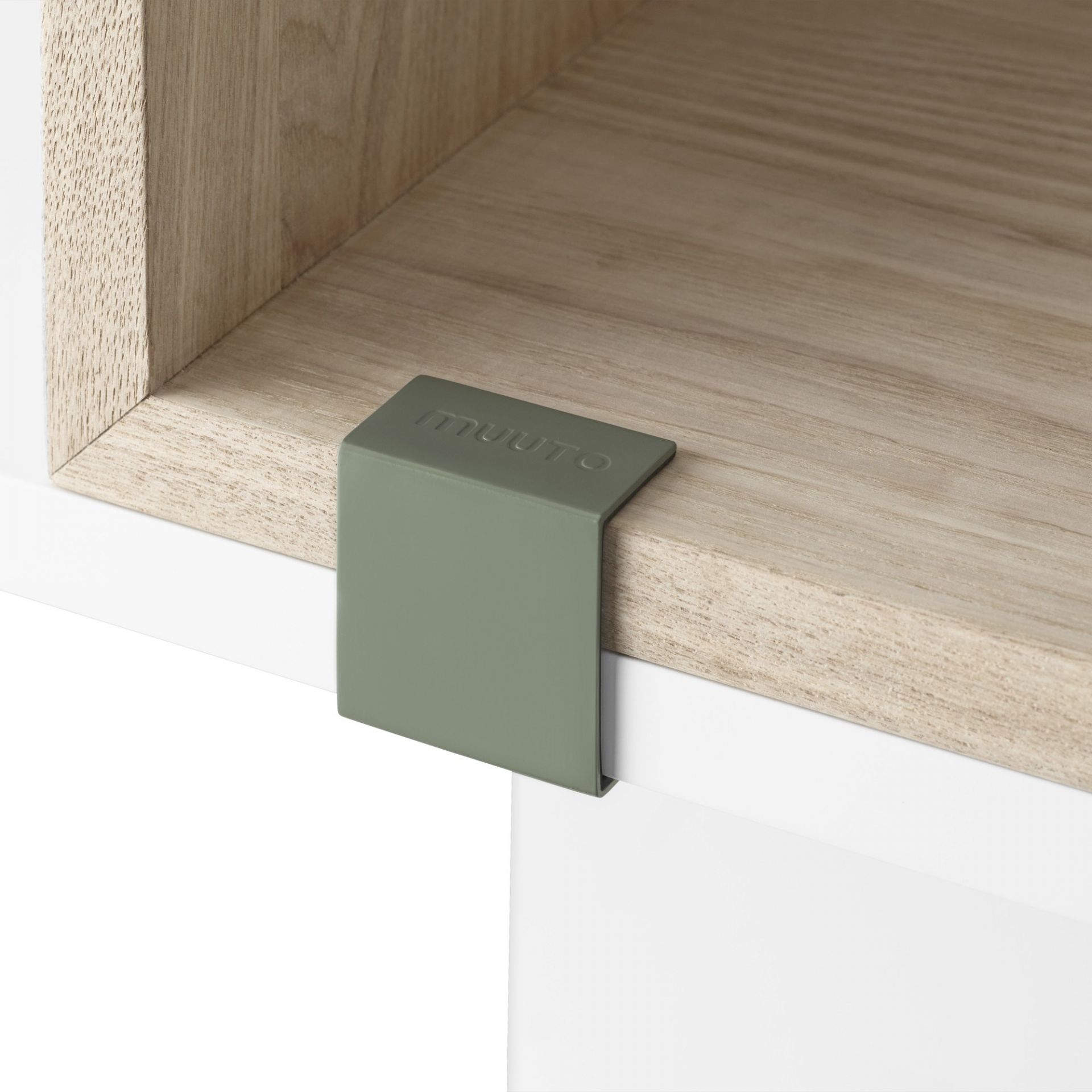 Detailaufnahme des Muuto Stacked Storage Systems 2.0: Grüner Clip verbindet Regale aus hellem Holz und Weiß.