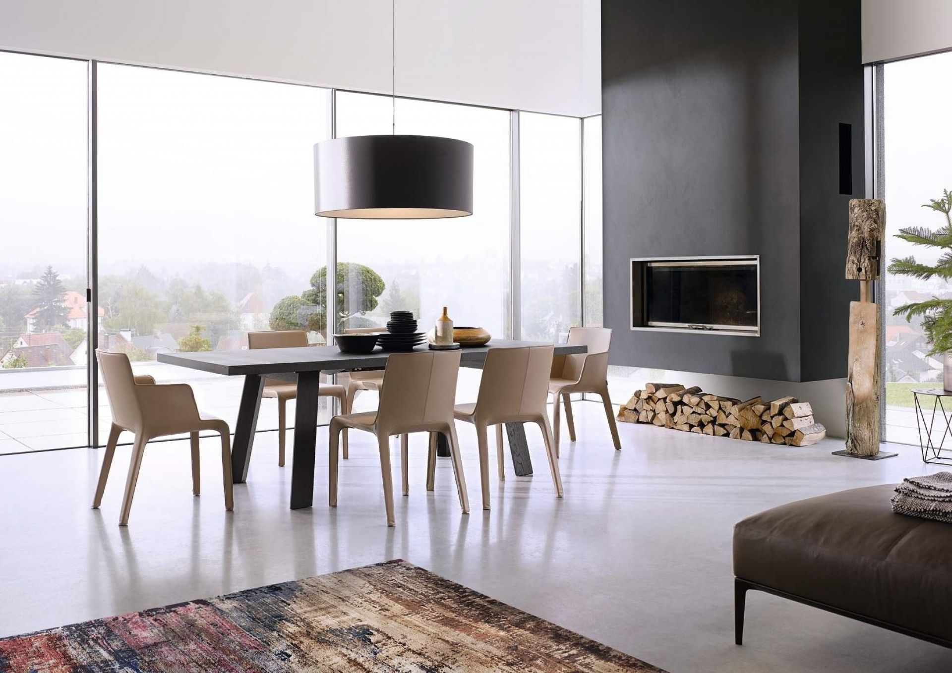 Moderner Essbereich mit Walter Knoll Tadeo Table Tisch und beigen Stühlen vor Panoramafenster und Kamin.
