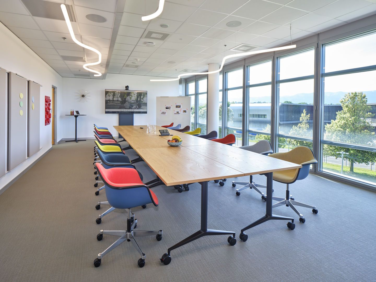 Konferenzraum mit langem MedaMorph Klapptisch von Vitra und farbigen Bürostühlen für Besprechungen.