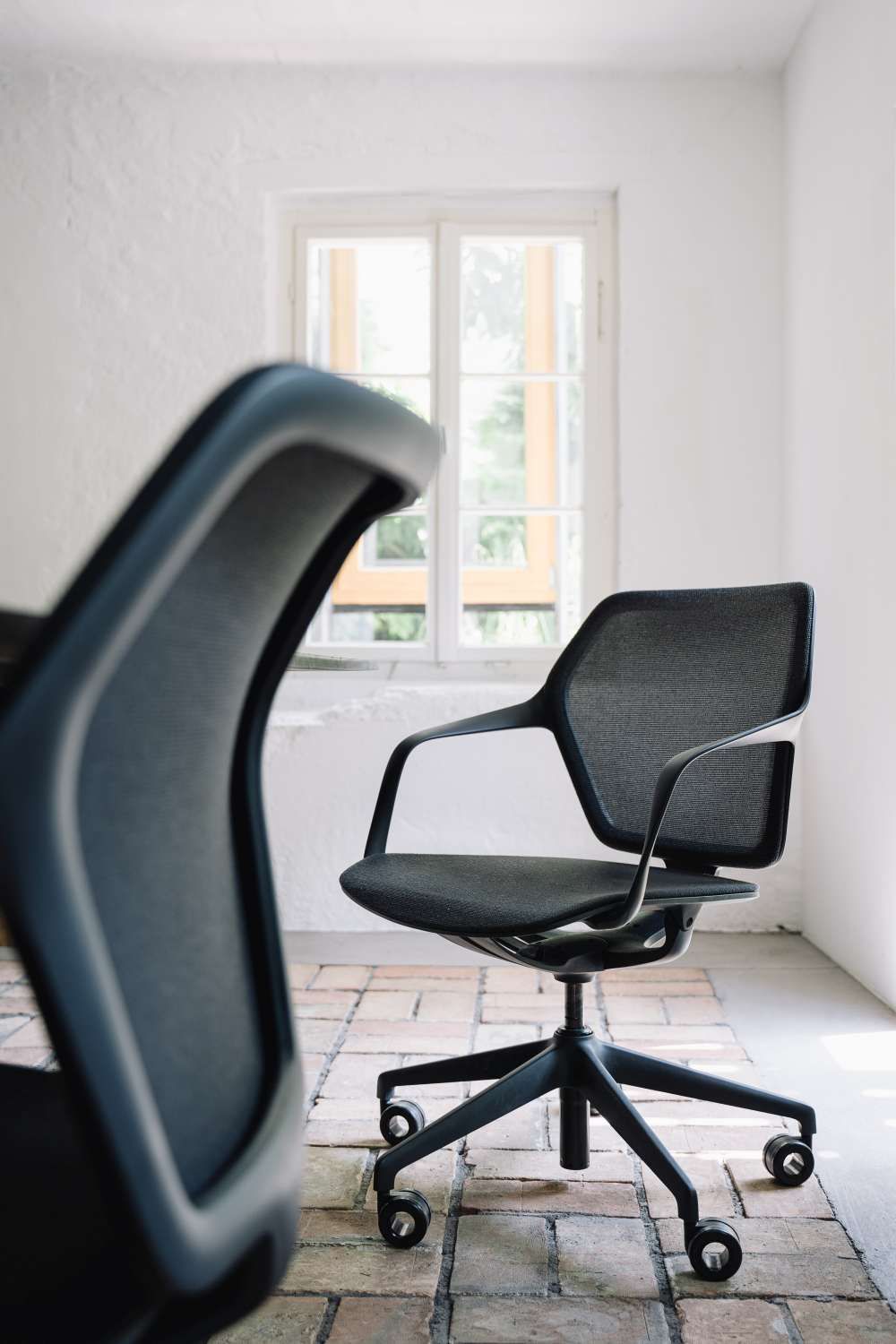 Ray Work Bürodrehstuhl von Brunner mit schwarzem Netzrücken und Armlehnen vor hellem Hintergrund.