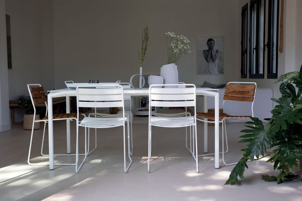 Essgruppe mit weißen Fermob Surprising Teak Stühlen und Tisch für den Garten oder die Terrasse.