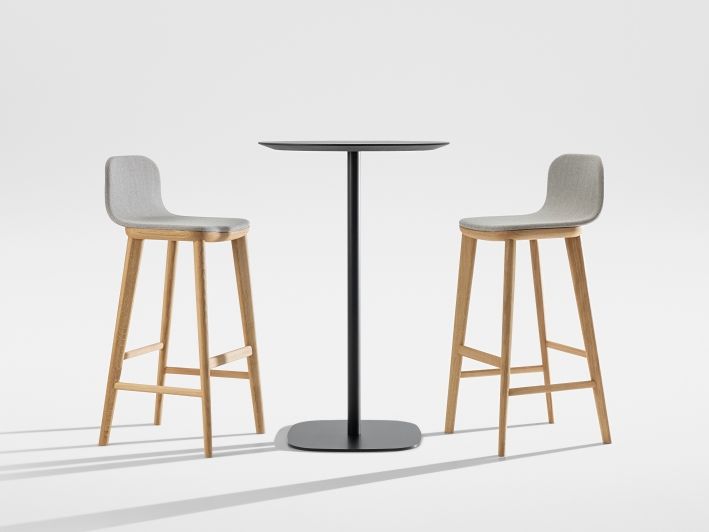 Aeon Barstool: Zwei moderne Barhocker mit grauem Bezug und Holzelementen an einem schwarzen Bartisch.