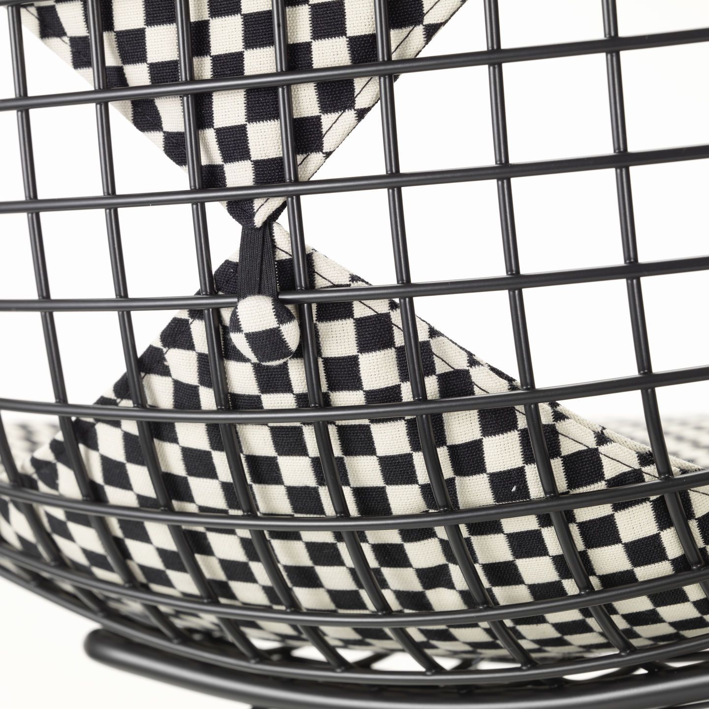 Detailaufnahme des DKW-2 Wire Chair Stuhls von Vitra mit schwarz-weiß kariertem Sitz- und Rückenpolster.