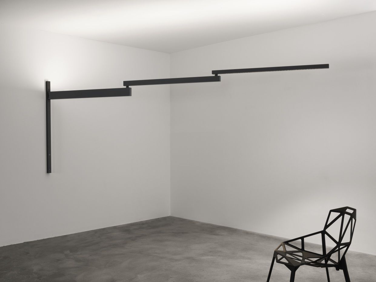 Schwarze Flos Black Flag Pro LED Wandleuchte mit schwenkbaren Armen in einem minimalistischen Raum.