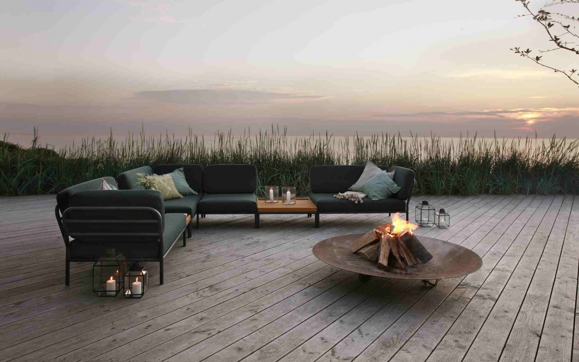 Houe Level Outdoor Sofa Lounge-Set mit Feuerstelle und Meerblick für entspannte Sommerabende.