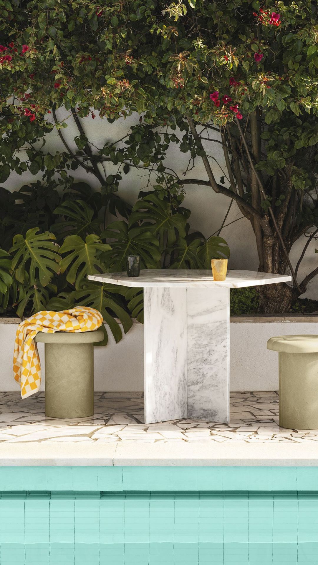 Alder Stool Hocker von Mater für den Innen- und Außenbereich, mit gelbem Tuch dekoriert.