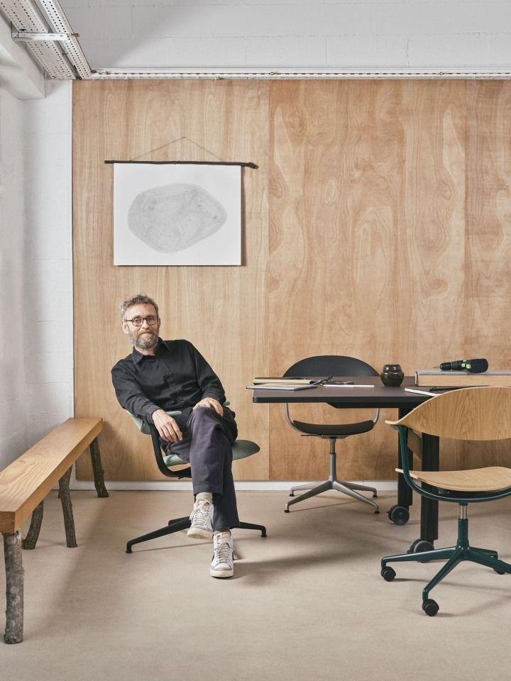 Mann sitzt auf einem Mynt Bürodrehstuhl von Vitra, bequeme Polsterung, ergonomisches Design, modernes Büroambiente.